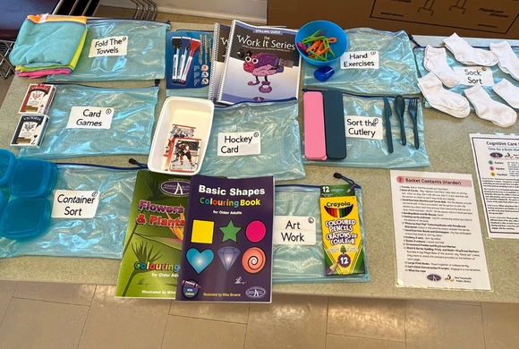 Photograph of the contents of a Cognitive Care Kit spread out across a table. 